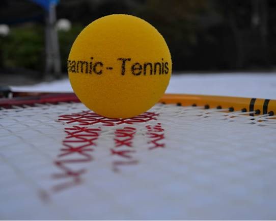 Een gele bal met de tekst dynamic tennis op een racket